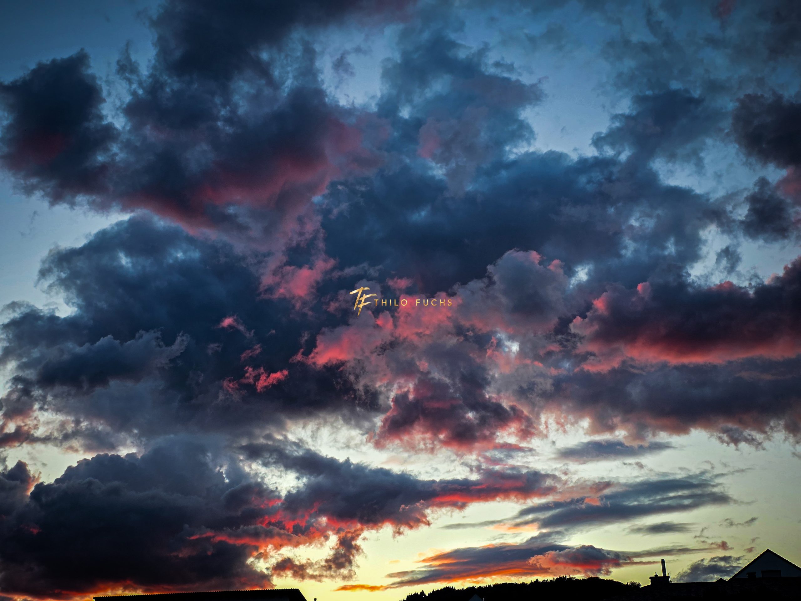 Zwischen Dunkelheit und Licht: Ein Abendhimmel in fünf Momenten Dunkle Wolkenfelder mit roten Lichtspuren über einer silhouettierten Landschaft beim Sonnenuntergang.